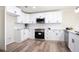 Bright updated kitchen with white cabinets, stainless steel appliances, and wood-look floors offers a clean design at 300 Saddle Creek Ln, Roswell, GA 30076