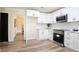 Bright updated kitchen with white cabinets, stainless steel appliances, and wood-look floors offers a clean design at 300 Saddle Creek Ln, Roswell, GA 30076