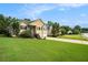 Well-manicured home exterior with a sprawling front lawn, mature trees, and a two-car garage at 4077 High Country Dr, Douglasville, GA 30135