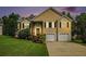 Charming two-story home at twilight featuring manicured lawn, two car garage, and classic front door with decorative window at 4077 High Country Dr, Douglasville, GA 30135