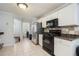 Bright eat-in kitchen with white cabinets, dark countertops, tile floors, and modern stainless steel appliances at 4077 High Country Dr, Douglasville, GA 30135