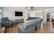 Open living room featuring hardwood floors, high ceilings, and large gray sectional sofa with recliner at 4077 High Country Dr, Douglasville, GA 30135