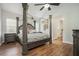 Beautiful primary bedroom features a four poster bed, wood flooring, and vaulted ceilings at 4077 High Country Dr, Douglasville, GA 30135