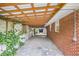 Covered carport area with brick exterior, mature greenery, and ample space creating a practical and appealing outdoor space at 734 Meadowlark Dr, Villa Rica, GA 30180