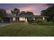 Charming brick home with a well-maintained front yard with a carport and illuminated windows at dusk at 734 Meadowlark Dr, Villa Rica, GA 30180