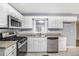 Close up of kitchen featuring white cabinets, stainless steel appliances, and tile flooring at 734 Meadowlark Dr, Villa Rica, GA 30180