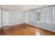 Living room featuring beautiful hardwood floors, neutral-colored walls, a window, and a white door at 734 Meadowlark Dr, Villa Rica, GA 30180