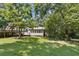 Backyard view featuring a deck, home, and lush green lawn at 136 Pine St, Covington, GA 30014