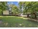 Expansive backyard with a deck, lush lawn, and mature trees at 136 Pine St, Covington, GA 30014
