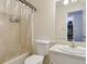 Neat bathroom featuring a shower with curtain, modern toilet, sink with chrome faucet and framed mirror at 136 Pine St, Covington, GA 30014