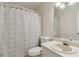 Well-lit bathroom featuring a modern toilet, shower with decorative curtain, and sink with chrome faucet at 136 Pine St, Covington, GA 30014
