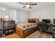 Comfortable bedroom featuring a ceiling fan, wood floors, a bed, and a desk for study or work at 136 Pine St, Covington, GA 30014