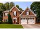 Charming two-story brick home featuring a well-maintained lawn, two-car garage and inviting red front door at 1767 Tidewell Trce, Lawrenceville, GA 30043