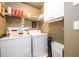 Convenient laundry room equipped with washer, dryer, and ample storage shelves at 1767 Tidewell Trce, Lawrenceville, GA 30043