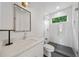 Modern bathroom with white tile, glass shower, and sleek vanity with stone countertop at 32 Walthall Ne St # A, Atlanta, GA 30307