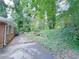 View of home's exterior with a retaining wall, landscaping, and mature trees at 4103 Indian Creek Cir, Stone Mountain, GA 30083