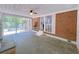 Bright sunroom with brick accent wall, stone floors, ceiling fan, and access to the outdoors at 4103 Indian Creek Cir, Stone Mountain, GA 30083