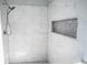 Shower featuring marble tiles, built-in shelving, and a modern shower head at 4569 Campenille Trce, Suwanee, GA 30024