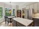 Bright eat-in kitchen with stainless appliances, gray cabinets, island with marble countertop, and a bay window at 2177 Mauldin Nw St, Atlanta, GA 30318