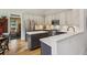 Modern eat-in kitchen with stainless appliances, gray and white cabinets, island with marble countertop and wood flooring at 2177 Mauldin Nw St, Atlanta, GA 30318