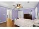 This bedroom features a ceiling fan, wooden floors and light purple walls at 3511 Stone Cliff Way, Woodstock, GA 30189
