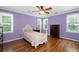 Charming bedroom with abundant natural light, purple walls, and hardwood floors at 3511 Stone Cliff Way, Woodstock, GA 30189