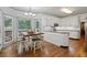 Eat-in kitchen with an abundance of natural light, white cabinetry, and hardwood flooring at 3511 Stone Cliff Way, Woodstock, GA 30189