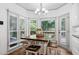 Sunlit eat-in kitchen features a wooden table, seating, and views of the backyard at 3511 Stone Cliff Way, Woodstock, GA 30189