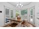 Sunlit eat-in kitchen with hardwood flooring, a wooden table, and views of the backyard at 3511 Stone Cliff Way, Woodstock, GA 30189