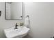 Stylish powder room with a pedestal sink, modern fixtures, and neutral walls at 3511 Stone Cliff Way, Woodstock, GA 30189