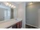Bathroom features a large mirror, a vanity with wooden cabinets and modern fixtures, and tub-shower at 4185 Post Oak Grv, Atlanta, GA 30349