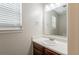 This bathroom features a bright window, a mirror, vanity, and wooden cabinets at 4185 Post Oak Grv, Atlanta, GA 30349