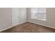 Cozy bedroom with neutral walls, plush carpeting, a window letting in natural light, and a closet at 4185 Post Oak Grv, Atlanta, GA 30349