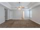 Large carpeted main bedroom with tray ceiling, fan, neutral walls and lots of light at 4185 Post Oak Grv, Atlanta, GA 30349