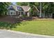 Well-manicured front lawn of a two-story house with mature trees, and a bay window at 912 Spring Vly, Woodstock, GA 30189