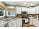 Bright kitchen with stainless steel appliances, granite countertops, and a window over the sink at 912 Spring Vly, Woodstock, GA 30189