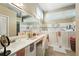 Bright bathroom featuring a walk in tub, double sinks, large mirrors, and many windows at 912 Spring Vly, Woodstock, GA 30189