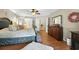 Large bedroom with steps up to bed, ceiling fan, wood floors, and dark wood dresser at 912 Spring Vly, Woodstock, GA 30189
