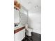 Stylish powder room featuring patterned wallpaper, wood-trimmed vanity, modern fixtures, and sleek black tile floors at 941 Garibaldi Sw St, Atlanta, GA 30310