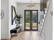A bright entryway featuring wood floors, staircase with unique railing, modern lighting and large black framed glass doors at 941 Garibaldi Sw St, Atlanta, GA 30310