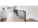 Bright hallway with light wood flooring, black metal railing, and a convenient sink area near the window at 941 Garibaldi Sw St, Atlanta, GA 30310