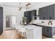 A well-lit kitchen features gray cabinets, stainless steel appliances, a marble countertop, and bar stool seating at 941 Garibaldi Sw St, Atlanta, GA 30310