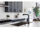 A kitchen with white countertops, gray cabinets, and stainless steel appliances has modern fixtures and ample natural light at 941 Garibaldi Sw St, Atlanta, GA 30310