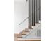 Modern staircase with wood treads, white risers, and a gray accent wall, providing a sleek and stylish design at 941 Garibaldi Sw St, Atlanta, GA 30310
