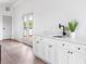 Charming wet bar with white cabinets, quartz countertops, black fixtures, and access to a deck via French doors at 941 Garibaldi Sw St, Atlanta, GA 30310