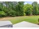 Lush green backyard with mature trees, perfect for outdoor activities and relaxation at 1524 Guthrie Crossing Dr, Loganville, GA 30052