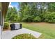Spacious backyard with a patio and grill, surrounded by lush greenery and trees at 1524 Guthrie Crossing Dr, Loganville, GA 30052
