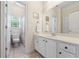 Well-lit bathroom showcasing a vanity, mirror, tile floors, and an adjacent toilet with a window at 1524 Guthrie Crossing Dr, Loganville, GA 30052