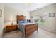 Bedroom with a classic wooden bed frame, a window with blinds, and soft neutral carpet at 1524 Guthrie Crossing Dr, Loganville, GA 30052
