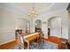 Elegant dining room with hardwood floors, wainscoting, and tray ceiling with decorative chandelier at 1524 Guthrie Crossing Dr, Loganville, GA 30052